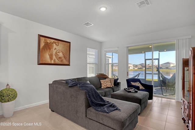 tiled living room featuring a water view