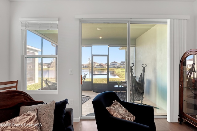 bedroom with a water view, multiple windows, and access to outside