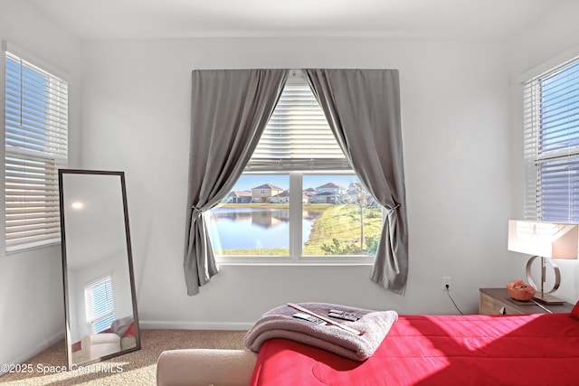 bedroom with a water view and carpet floors