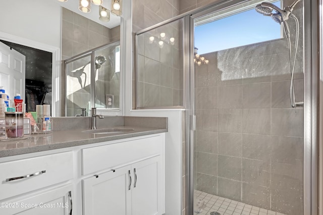 bathroom featuring a shower with door and vanity