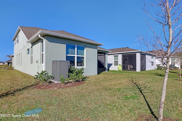 back of house with a sunroom, central AC, and a lawn