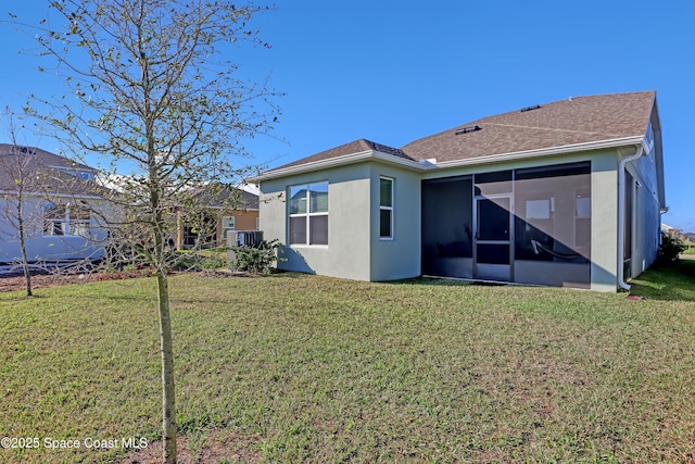 back of property with a sunroom, cooling unit, and a lawn