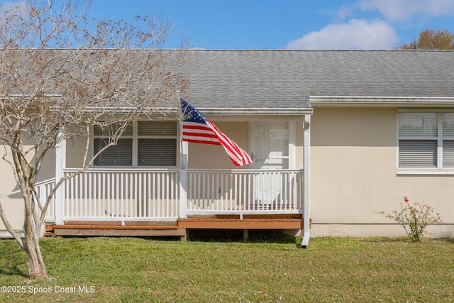 view of front of property with a porch, a front yard, and roof with shingles