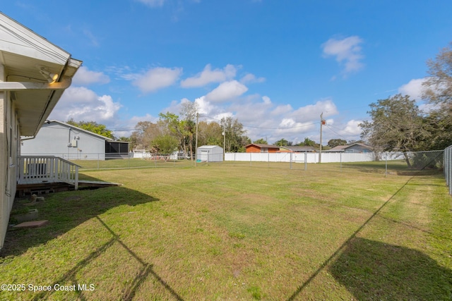 view of yard with a storage shed, a fenced backyard, and an outdoor structure