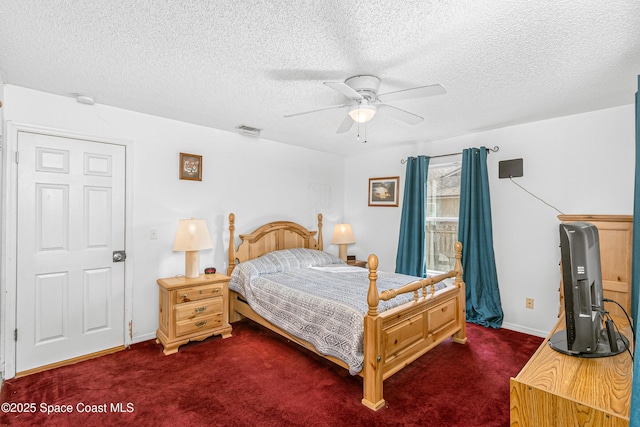 bedroom with dark colored carpet, visible vents, ceiling fan, and a textured ceiling