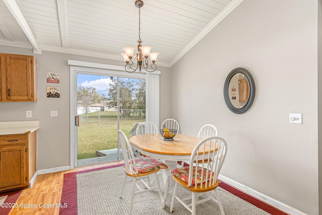 dining room featuring a chandelier, light wood finished floors, vaulted ceiling with beams, and baseboards