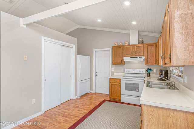 kitchen featuring white appliances, lofted ceiling, light countertops, under cabinet range hood, and a sink