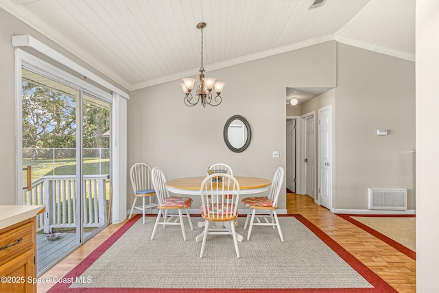 dining room with ornamental molding, visible vents, vaulted ceiling, and light wood finished floors