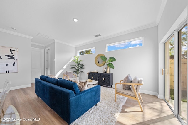 living room with crown molding, plenty of natural light, and light wood-type flooring