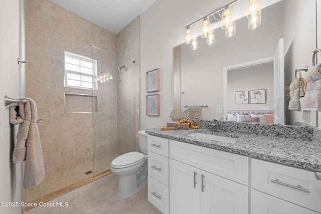 bathroom featuring tile patterned floors, vanity, toilet, and a tile shower