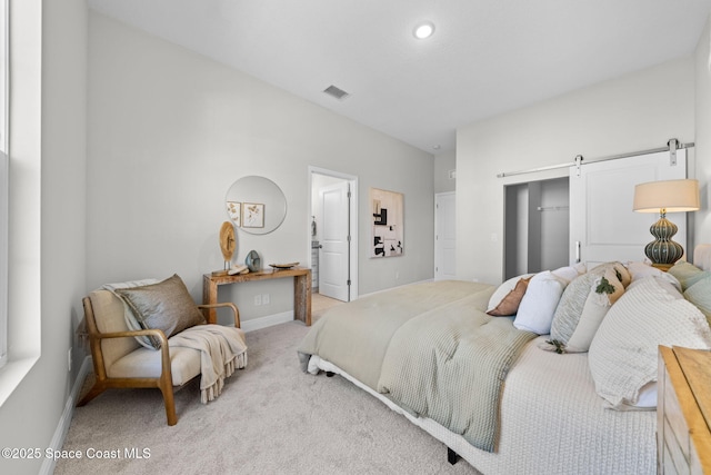 carpeted bedroom featuring a barn door