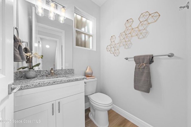 bathroom featuring vanity, wood-type flooring, and toilet