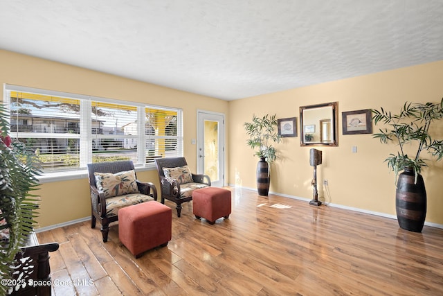 living area with hardwood / wood-style flooring and a textured ceiling