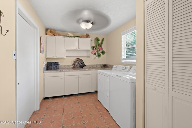 clothes washing area with cabinets, light tile patterned floors, a textured ceiling, and independent washer and dryer