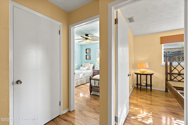 hallway with a wealth of natural light and light wood-type flooring