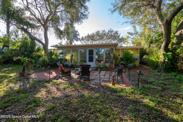 back of property featuring a sunroom and a patio