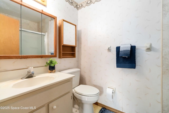 bathroom with vanity, toilet, and a shower with door