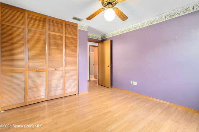 unfurnished bedroom with hardwood / wood-style flooring, a closet, and ceiling fan