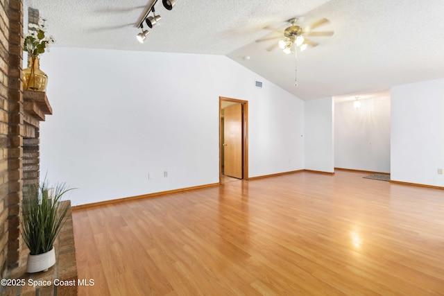 unfurnished living room featuring ceiling fan, lofted ceiling, a textured ceiling, and light hardwood / wood-style flooring