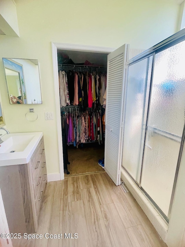 bathroom featuring vanity, an enclosed shower, and hardwood / wood-style floors