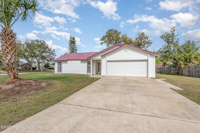 ranch-style house featuring metal roof, an attached garage, fence, concrete driveway, and a front lawn