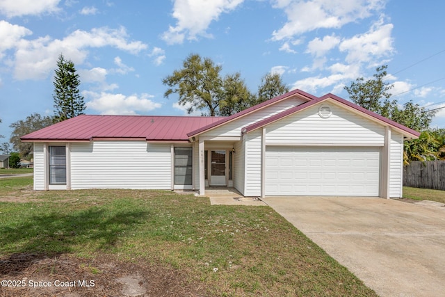 ranch-style home featuring metal roof, fence, a garage, driveway, and a front lawn