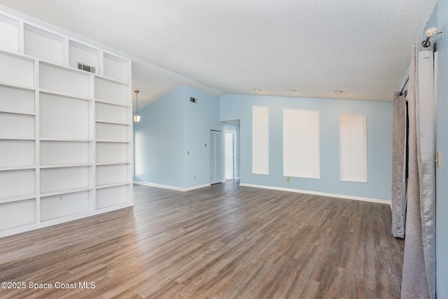 unfurnished living room with lofted ceiling, visible vents, and wood finished floors