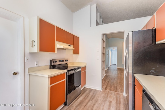 kitchen with under cabinet range hood, light wood-style floors, stainless steel appliances, and light countertops