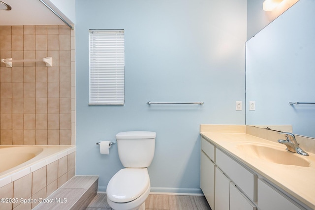 bathroom with baseboards, vanity, toilet, and wood finished floors