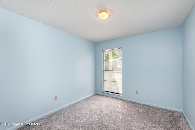 carpeted empty room with a textured ceiling and baseboards