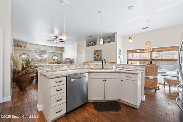 kitchen with sink, white cabinetry, decorative light fixtures, dishwasher, and light stone countertops