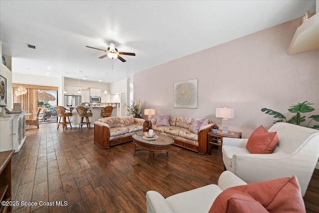 living room with dark wood-type flooring and ceiling fan