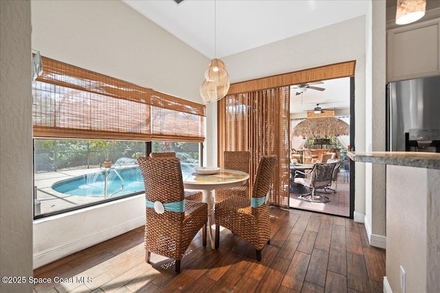 dining space featuring lofted ceiling, hardwood / wood-style flooring, and ceiling fan