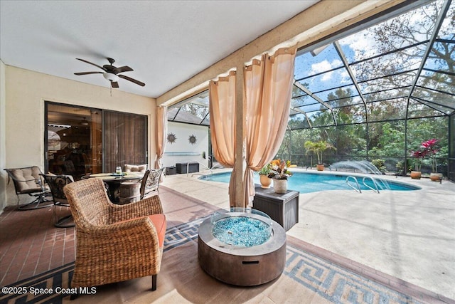 view of patio / terrace featuring ceiling fan, an outdoor fire pit, and a lanai