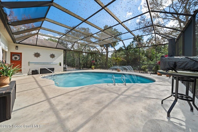 view of swimming pool featuring a patio area, pool water feature, and glass enclosure