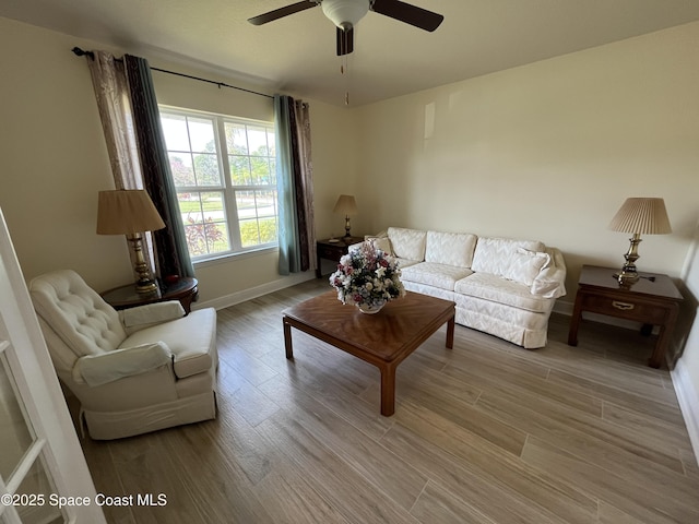 living room with light hardwood / wood-style flooring and ceiling fan