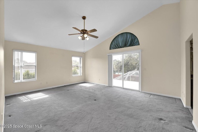 spare room with ceiling fan, high vaulted ceiling, and light carpet