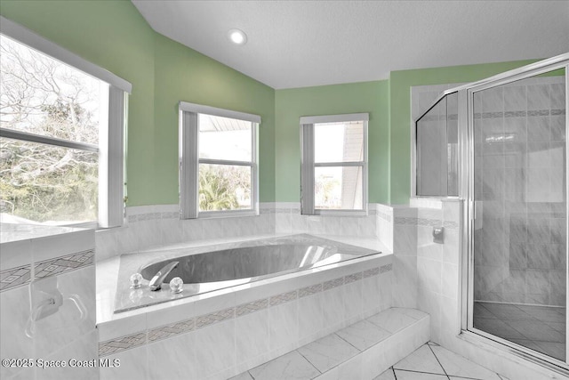 bathroom with lofted ceiling, independent shower and bath, tile patterned flooring, and a textured ceiling