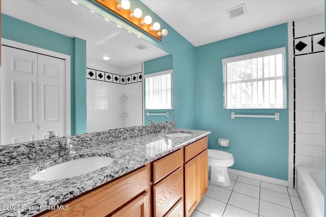 full bathroom with vanity, toilet, tiled shower / bath combo, and tile patterned flooring