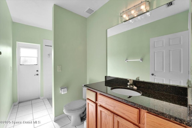 bathroom featuring vanity, tile patterned floors, and toilet