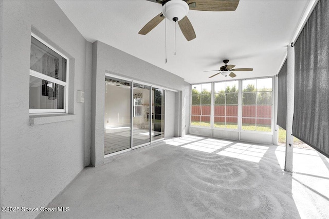 unfurnished sunroom featuring ceiling fan