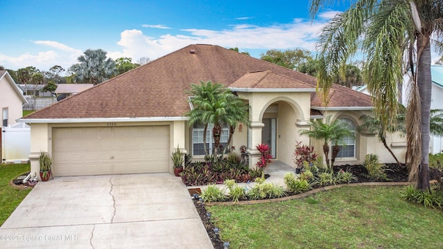 view of front of property with concrete driveway, roof with shingles, an attached garage, a front lawn, and stucco siding