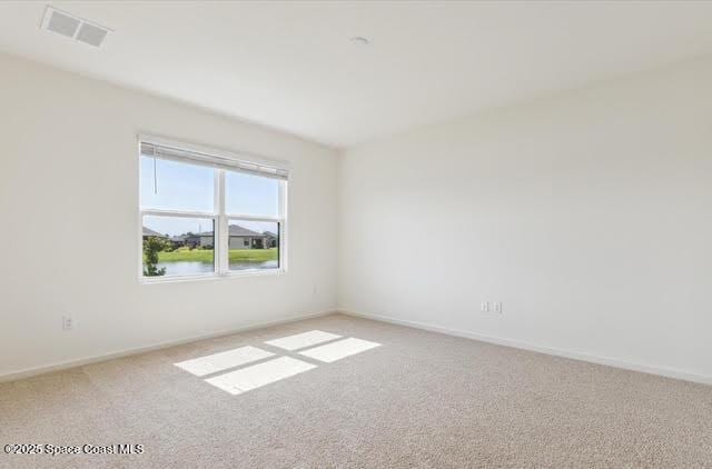 spare room featuring light carpet