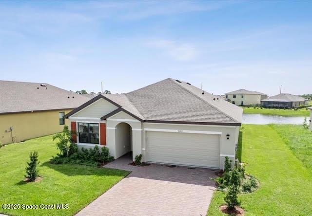 single story home featuring a water view, a garage, and a front yard