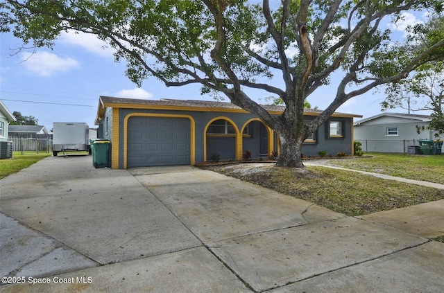 ranch-style house with a garage, central AC unit, and a front yard