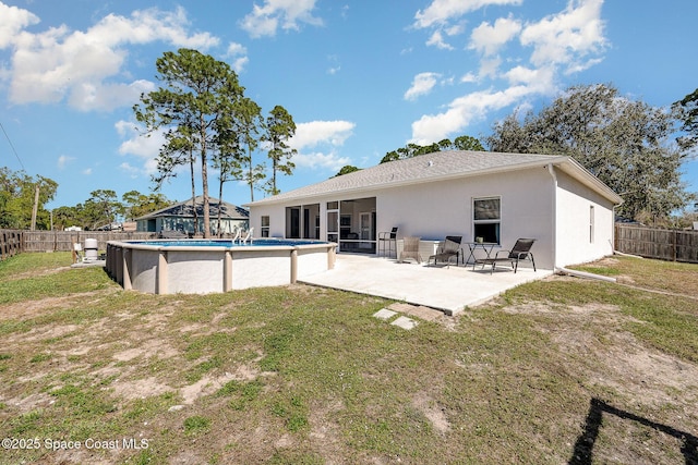 back of property featuring a lawn, a sunroom, a patio area, and a fenced in pool