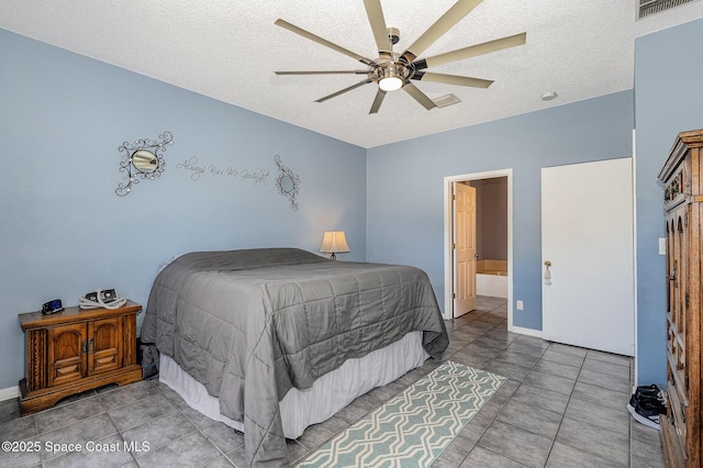 bedroom with a textured ceiling, connected bathroom, and ceiling fan