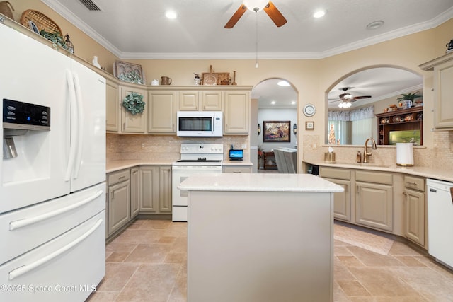 kitchen featuring ornamental molding, a kitchen island, sink, and white appliances