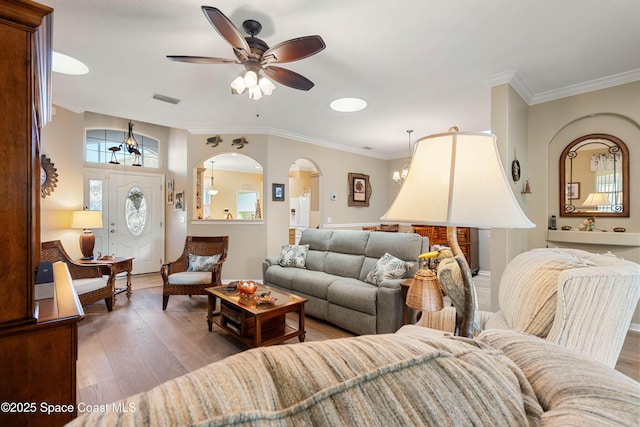 living room featuring ceiling fan, ornamental molding, and wood-type flooring