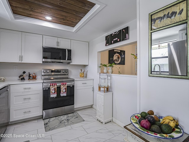 kitchen featuring white cabinetry, wooden ceiling, a raised ceiling, and appliances with stainless steel finishes